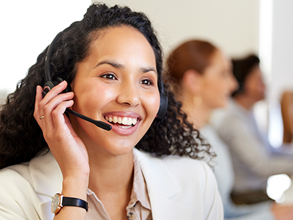 A young call center agent working in an office with her colleagues in the background