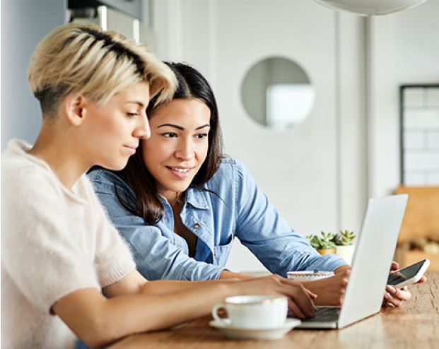 Two women looking at the same laptop