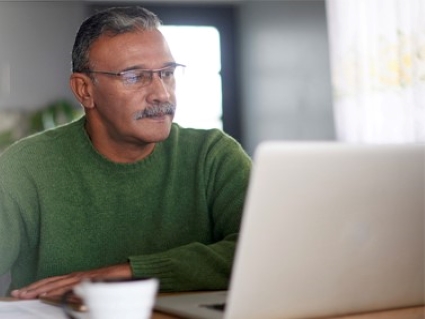 Decorative image of a man looking at his laptop.